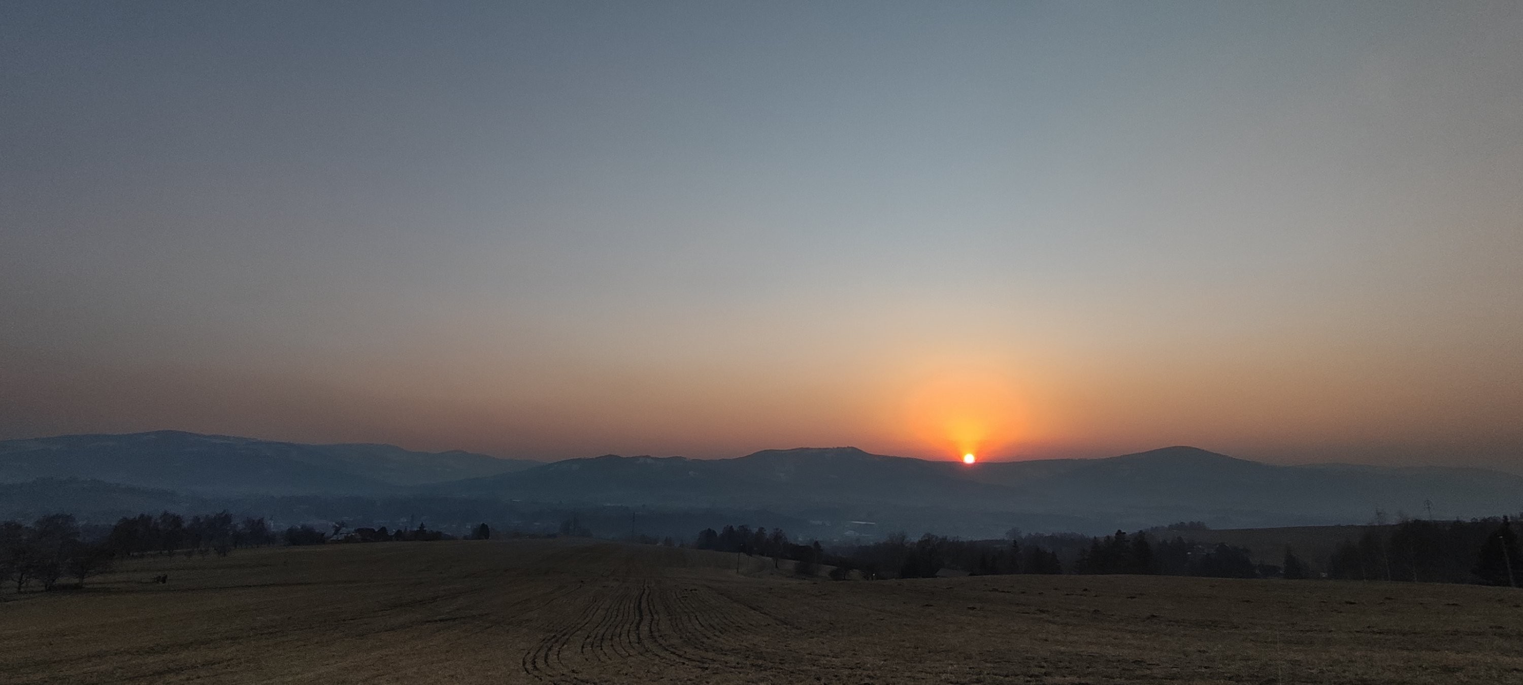 Západ slunce přes prach ze Sahary
